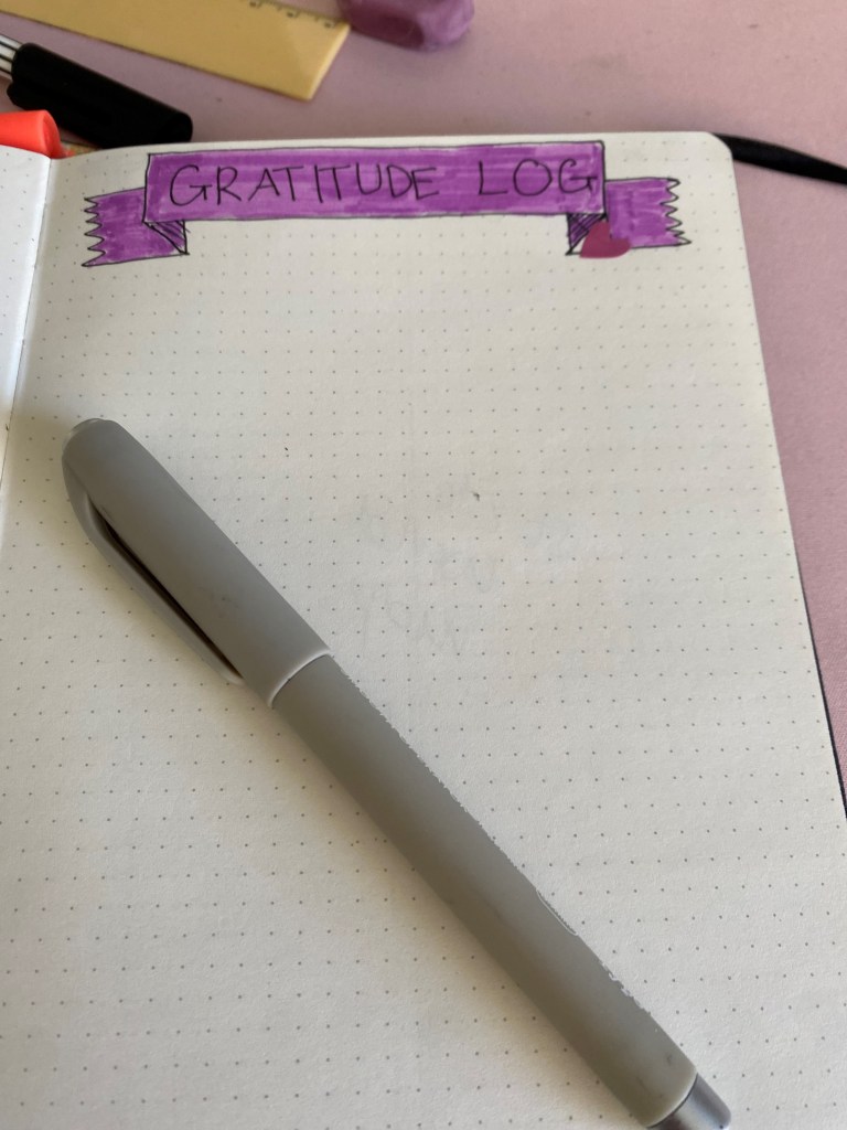 Blank page, with header "Gratitude log" and pen lying on the page